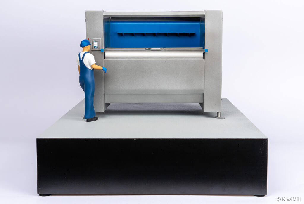 Belt chiller scale model front view with blue flighted belt, operator figure at touchscreen, and black display base